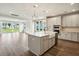 Bright open kitchen features white cabinets, stainless appliances, farmhouse sink, and hardwood floors at 210 Quimby Hill Dr, Huger, SC 29450