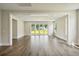 Open-concept living room features light-colored hardwood floors, modern white trim, and sliding glass doors at 210 Quimby Hill Dr, Huger, SC 29450