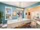 Light and airy dining room featuring light fixture, blue walls, white-clothed table, and large window at 217 Woodland Oak Way, Summerville, SC 29485