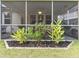 Landscaped yard with a glimpse of the screened porch and exterior features at 217 Woodland Oak Way, Summerville, SC 29485