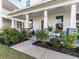 Covered front porch with seating area, lush landscaping, and cozy atmosphere at 217 Woodland Oak Way, Summerville, SC 29485