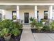 Inviting front porch with cozy seating, plants and decorative accents at 217 Woodland Oak Way, Summerville, SC 29485
