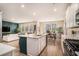 Open-concept kitchen with a central island, dining area, and a view into the living room at 217 Woodland Oak Way, Summerville, SC 29485