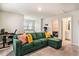 Cozy living area with green couch, bright pillows, and natural light from two windows at 217 Woodland Oak Way, Summerville, SC 29485