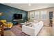 Contemporary living room featuring sleek blue accent wall, stylish decor, and plenty of natural light at 217 Woodland Oak Way, Summerville, SC 29485