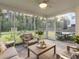 Relaxing screened-in porch with comfortable seating, ceiling fan, and a view of the backyard at 217 Woodland Oak Way, Summerville, SC 29485