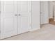 Carpeted bedroom with white closet doors, offering ample storage and neutral decor at 2254 Macallan Blvd, Ravenel, SC 29470
