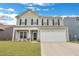 Charming two-story home with a welcoming front yard and a two-car garage, enhanced by black shutters and updated siding at 231 Hayworth Rd, Summerville, SC 29486