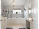 Bright bathroom features a soaking tub under a window and elegant chandelier at 2900 Colonnade Dr, Mount Pleasant, SC 29466