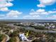 Overhead view of waterfront home, beautifully landscaped, nestled among trees with water views and blue skies at 3019 Eventide Dr, Johns Island, SC 29455
