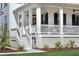 Inviting white front porch with classic columns, stairs, and tasteful landscaping at 3019 Eventide Dr, Johns Island, SC 29455