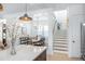 Eat-in kitchen with island, pendant lights, white cabinets, and access to dining room and stairway at 3019 Eventide Dr, Johns Island, SC 29455