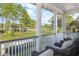 Covered porch featuring comfortable seating and serene nature views with green grass and tall trees at 3019 Eventide Dr, Johns Island, SC 29455