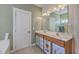 Charming bathroom featuring double sinks, wood cabinets, and ample light at 303 Crossandra Ave, Summerville, SC 29483