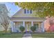 Charming yellow two-story home featuring a cozy front porch with white columns and manicured landscaping at 303 Crossandra Ave, Summerville, SC 29483