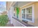 Inviting front porch featuring hanging flower baskets, stylish seating, and elegant details at 303 Crossandra Ave, Summerville, SC 29483