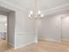 Dining room featuring light wood floors, neutral paint, modern chandelier, and open doorway at 3148 Vanessa Lynne Ln, Johns Island, SC 29455