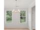 Dining room with light wood floors, neutral paint, modern chandelier, and large windows at 3148 Vanessa Lynne Ln, Johns Island, SC 29455