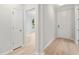 Hallway view featuring light wood floors, neutral paint, and white doors at 3148 Vanessa Lynne Ln, Johns Island, SC 29455