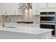 Close-up of kitchen with stainless steel oven and gas range, marble countertop, and tile backsplash at 3148 Vanessa Lynne Ln, Johns Island, SC 29455