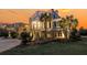 Beautiful two-story home with palm trees and professionally landscaped yard against a colorful evening sky at 3232 Pignatelli Cres, Mount Pleasant, SC 29466