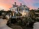 Charming multi-story home with inviting balconies and lush landscaping, enhanced by an evening glow at 3232 Pignatelli Cres, Mount Pleasant, SC 29466