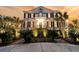 Charming home with a gated entrance, lush landscaping, and warm, inviting lighting at 3232 Pignatelli Cres, Mount Pleasant, SC 29466