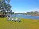 Scenic waterfront view with Adirondack chairs on the lawn overlooking the calm water at 3232 Pignatelli Cres, Mount Pleasant, SC 29466