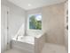 Modern bathroom featuring a large soaking tub and a glass-enclosed shower with marble tiling at 359 Blue Oak Dr, Moncks Corner, SC 29461