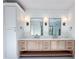 Bright bathroom featuring a double vanity with two mirrors, sconces, and storage cabinets at 3845 Delinger Dr, Mount Pleasant, SC 29466