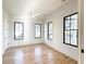 Bright bedroom featuring hardwood floors, three windows with black frames, white walls, and a ceiling fan at 3845 Delinger Dr, Mount Pleasant, SC 29466