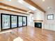 Spacious living room featuring hardwood floors, exposed wood beams, white walls, fireplace and sliding glass doors to an outdoor area at 3845 Delinger Dr, Mount Pleasant, SC 29466