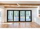 Bright living room featuring hardwood floors, exposed wood beams, white walls, and sliding glass doors to an outdoor area at 3845 Delinger Dr, Mount Pleasant, SC 29466