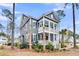 Two-story home with a covered porch and balcony, showcasing its architectural design and lush surrounding landscaping at 3851 Sawyers Island Dr, Mount Pleasant, SC 29466