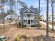 Elegant two-story home with a welcoming front porch, lush landscaping, and classic architectural details and blue siding at 3851 Sawyers Island Dr, Mount Pleasant, SC 29466