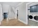 Inviting hallway with hardwood floors, leading to the laundry room and a staircase to the upper level at 3851 Sawyers Island Dr, Mount Pleasant, SC 29466