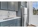 Charming kitchenette with stainless steel refrigerator, sink, quartz countertops and gray cabinets at 3851 Sawyers Island Dr, Mount Pleasant, SC 29466