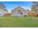 Large, grassy backyard with a privacy fence and a rear entrance to the home at 512 Resinwood Rd, Moncks Corner, SC 29461