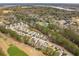 A wide aerial view capturing neighborhood homes next to a green golf course and a pond at 5358 Birdie Ln, Hollywood, SC 29449