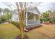 Cozy screened-in porch, a fire pit area, and a well-maintained lawn, perfect for relaxation at 5358 Birdie Ln, Hollywood, SC 29449