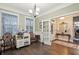 Light-filled dining area with hardwood floors, complemented by elegant chandelier and neutral walls at 5358 Birdie Ln, Hollywood, SC 29449