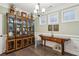 Stylish dining room features a large cabinet, hardwood floors, and natural light from two windows at 5358 Birdie Ln, Hollywood, SC 29449