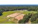 Aerial view of a well-maintained equestrian facility with riding arenas at 5358 Birdie Ln, Hollywood, SC 29449