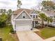 Beautifully landscaped two-story home with a garage and welcoming front porch at 5358 Birdie Ln, Hollywood, SC 29449