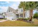 Charming home with light gray siding, two palm trees, a two car garage, and manicured lawn at 5358 Birdie Ln, Hollywood, SC 29449