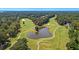 Scenic aerial view of a golf course featuring lush greenery, trees, and a pond at 5358 Birdie Ln, Hollywood, SC 29449