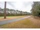 Manicured green space with trees, a golf course, and paved path at 5358 Birdie Ln, Hollywood, SC 29449