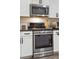 This kitchen features stainless steel oven, microwave and white subway tiles at 5358 Birdie Ln, Hollywood, SC 29449