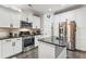 Well-lit kitchen features white cabinets, stainless steel appliances, and a center island with black countertop at 5358 Birdie Ln, Hollywood, SC 29449