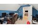 Home office featuring blue walls, a large desk, and an open doorway leading into another room at 5358 Birdie Ln, Hollywood, SC 29449